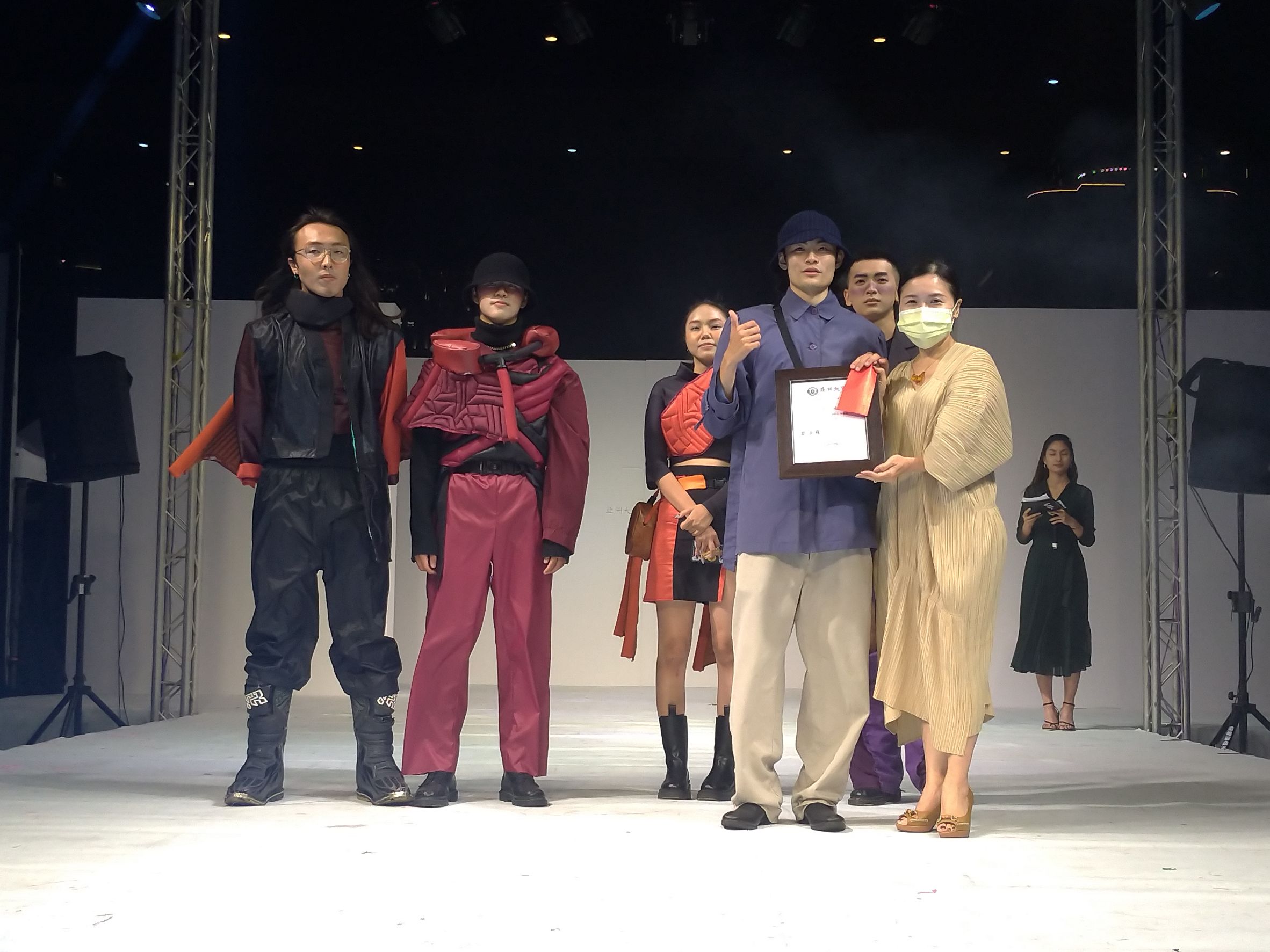 亞大時尚系主任林青玫(右一)頒獎給「掠時者」為題，獲第三名的范鈺偉同學(右二)。