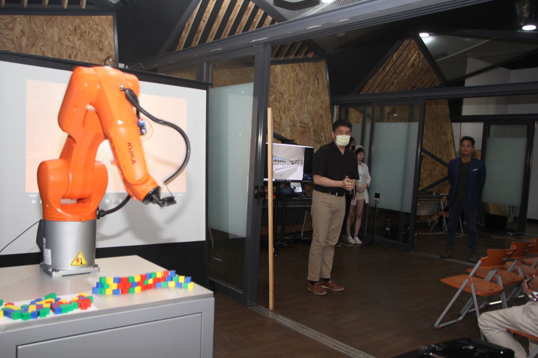 設計學院李元榮院長（左）與室內設計系老師施勝誠（中）介紹亞大設計學院引進的AI機械手臂，可協助學生完成室內設計模型。