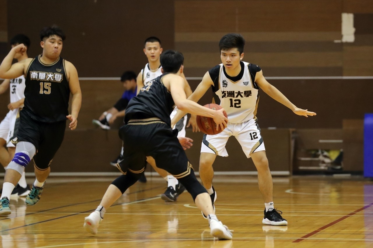 休憩系三年級同學林明瑋防守南華大學球員進攻。