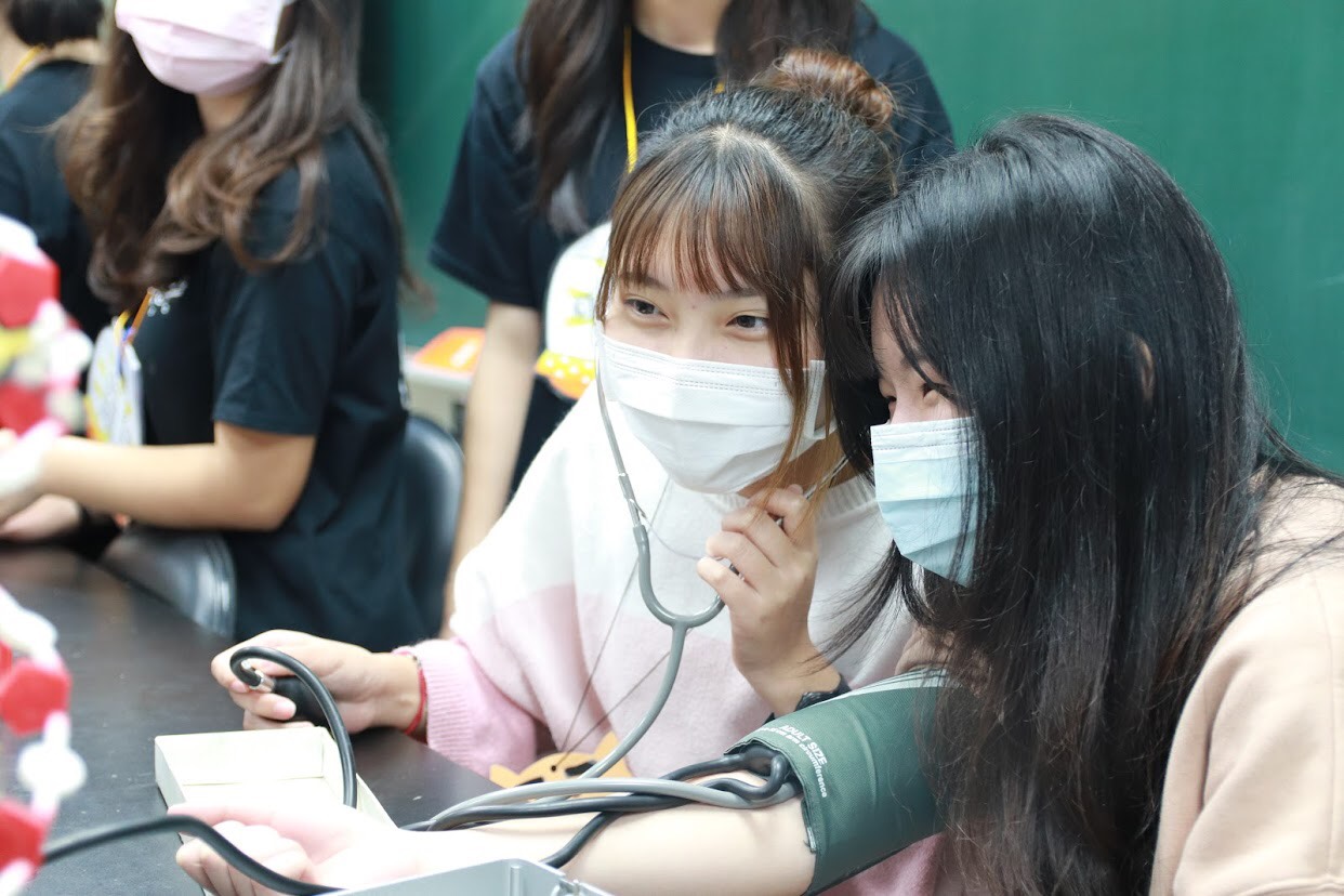 參加「第一屆亞大醫技營」的高中生利用血壓計，彼此檢驗血壓數據。