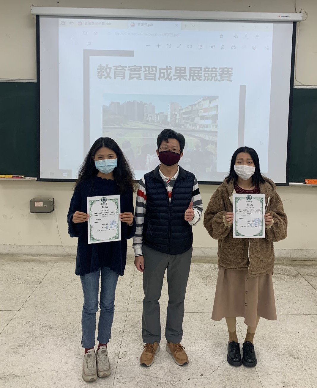 亞大幼教系主任陳昇飛(左二)頒獎給幼教系學生許楚筠（左一）、李文芸（左三）。