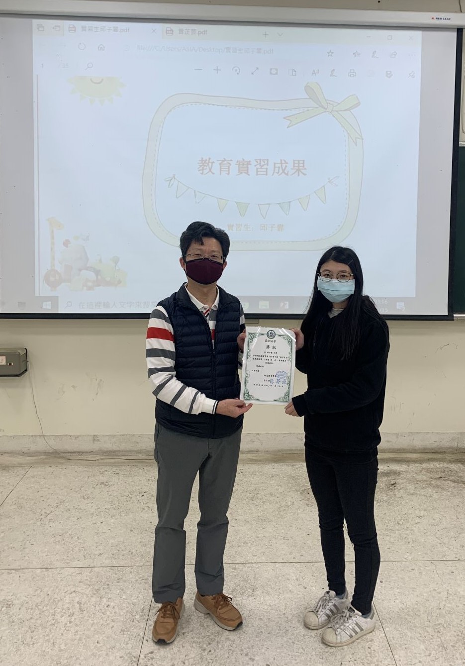 亞大幼教系主任陳昇飛(左)頒發第一名獎狀給邱子馨同學。