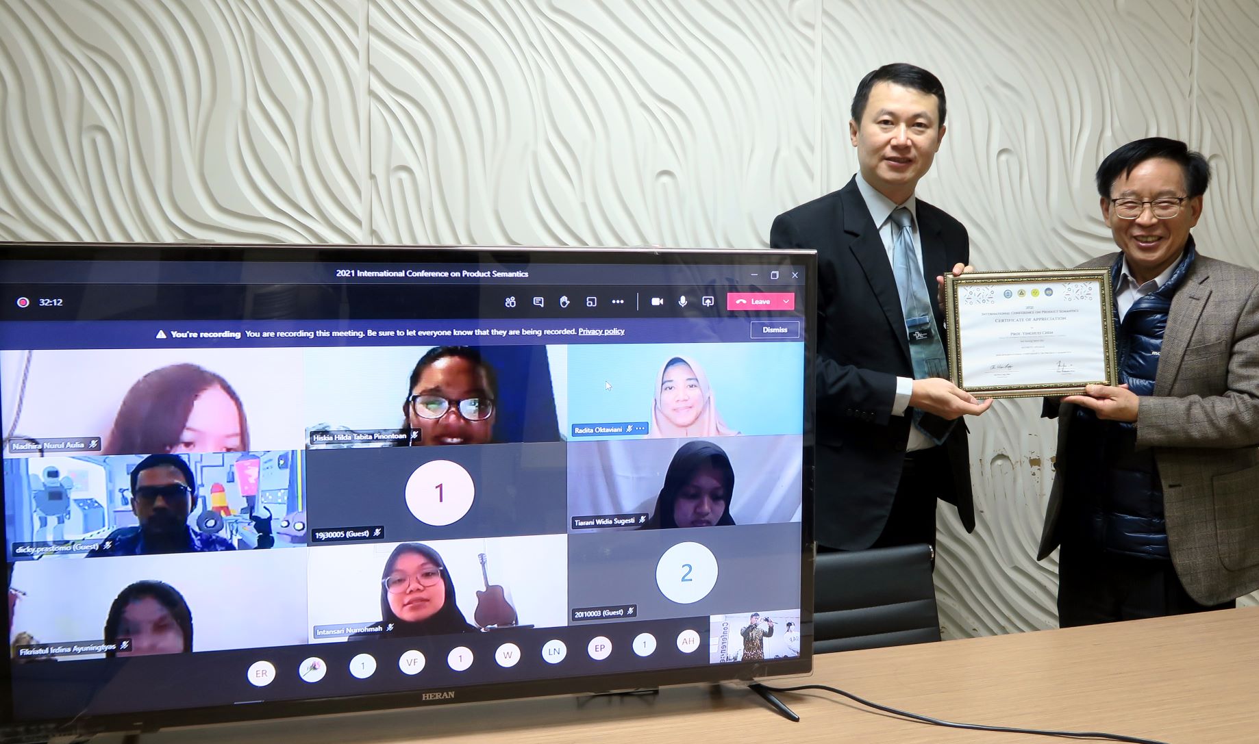 主辦研討會的商設系老師龍希文 (左) 頒發感謝狀給國際學院院長陳英輝。