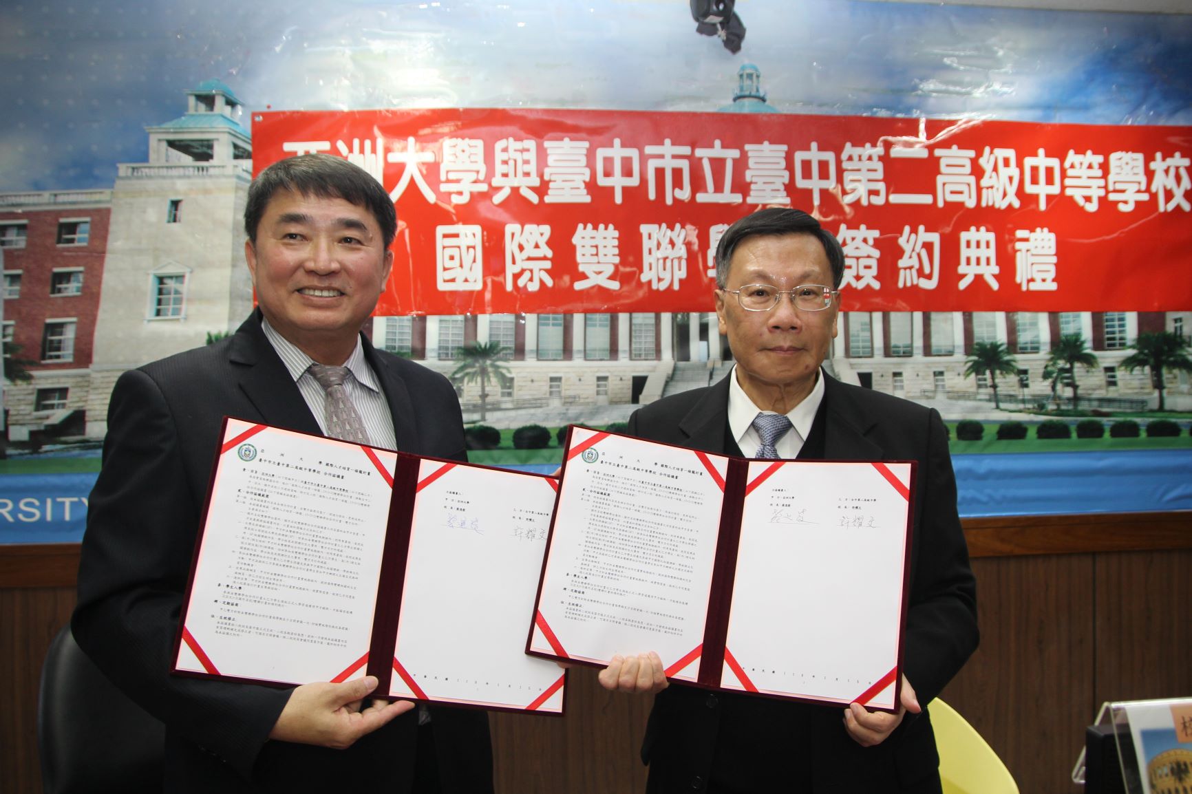 亞大校長蔡進發(右)與中二中校長許耀文，簽署兩校推動國際雙聯學位合約書。