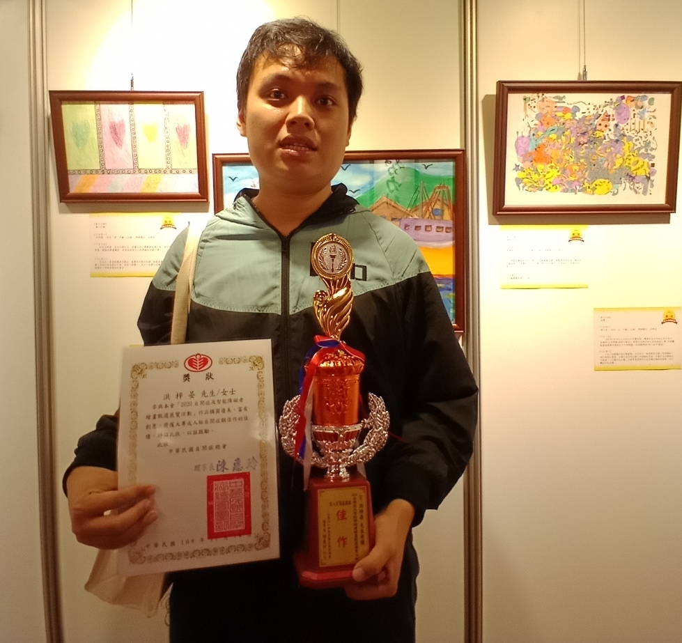 數媒系碩士生洪梓晏（右）以「愛心行動」作品，獲全國性身心障礙繪畫比賽成人組佳作。