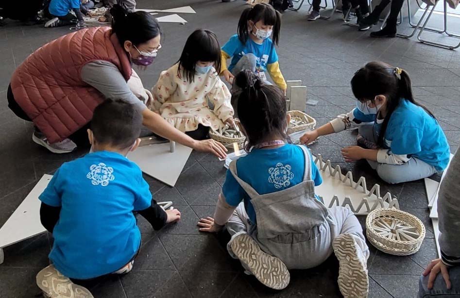 幼教系老师陈丽媜引导幼儿，使用计画教学团队自制的积木搭建美术馆