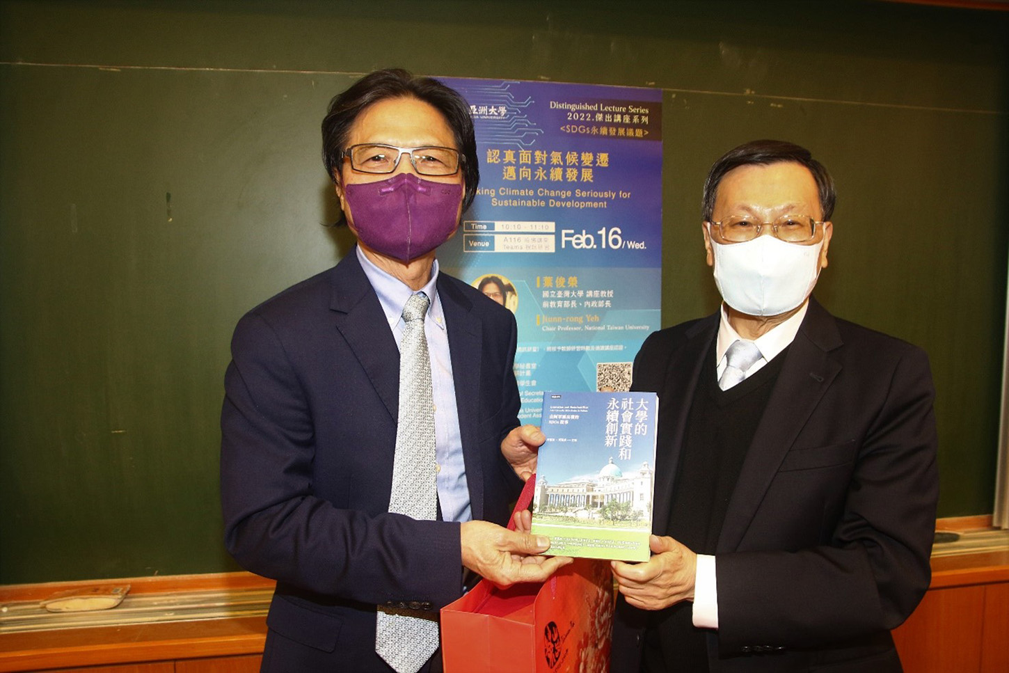 亞大校長蔡進發(右)贈送收錄亞大21個SDGs故事的「大學的社會實踐和永續創新」一書，給葉俊榮教授
