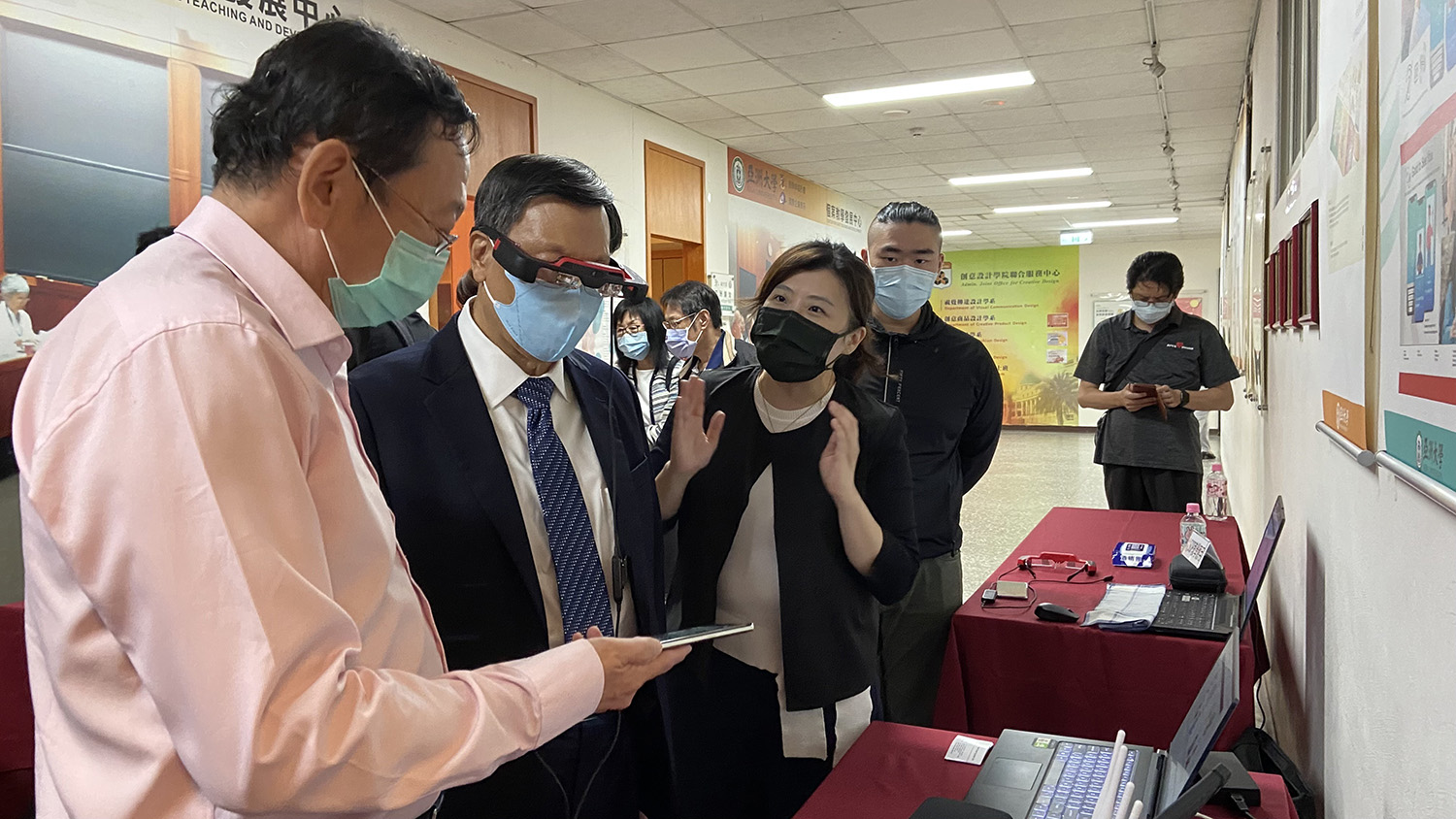 蔡進發校長（左二）戴上AR智慧眼鏡，聽取張國祥董事長（左一），介紹AR在醫療方面的應用
