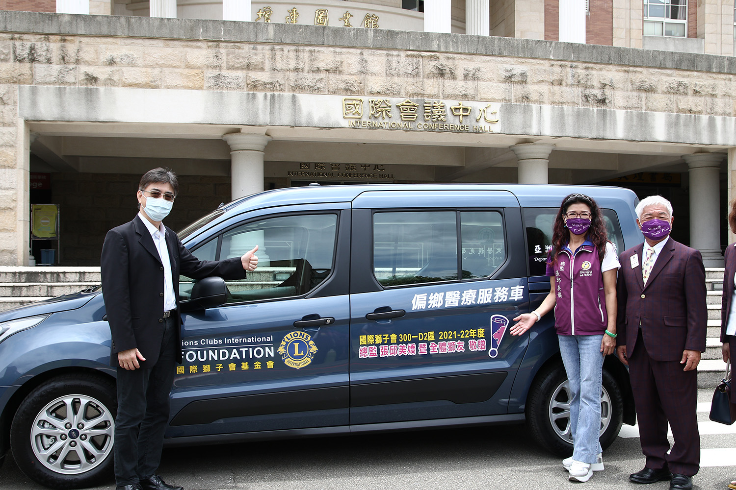 高屏300─D2區獅友捐贈一輛醫療服務車，由亞大副校長陳大正（左）代表接受，總監張邱美嬌（右二）、前總監林國泰（右一）捐贈
