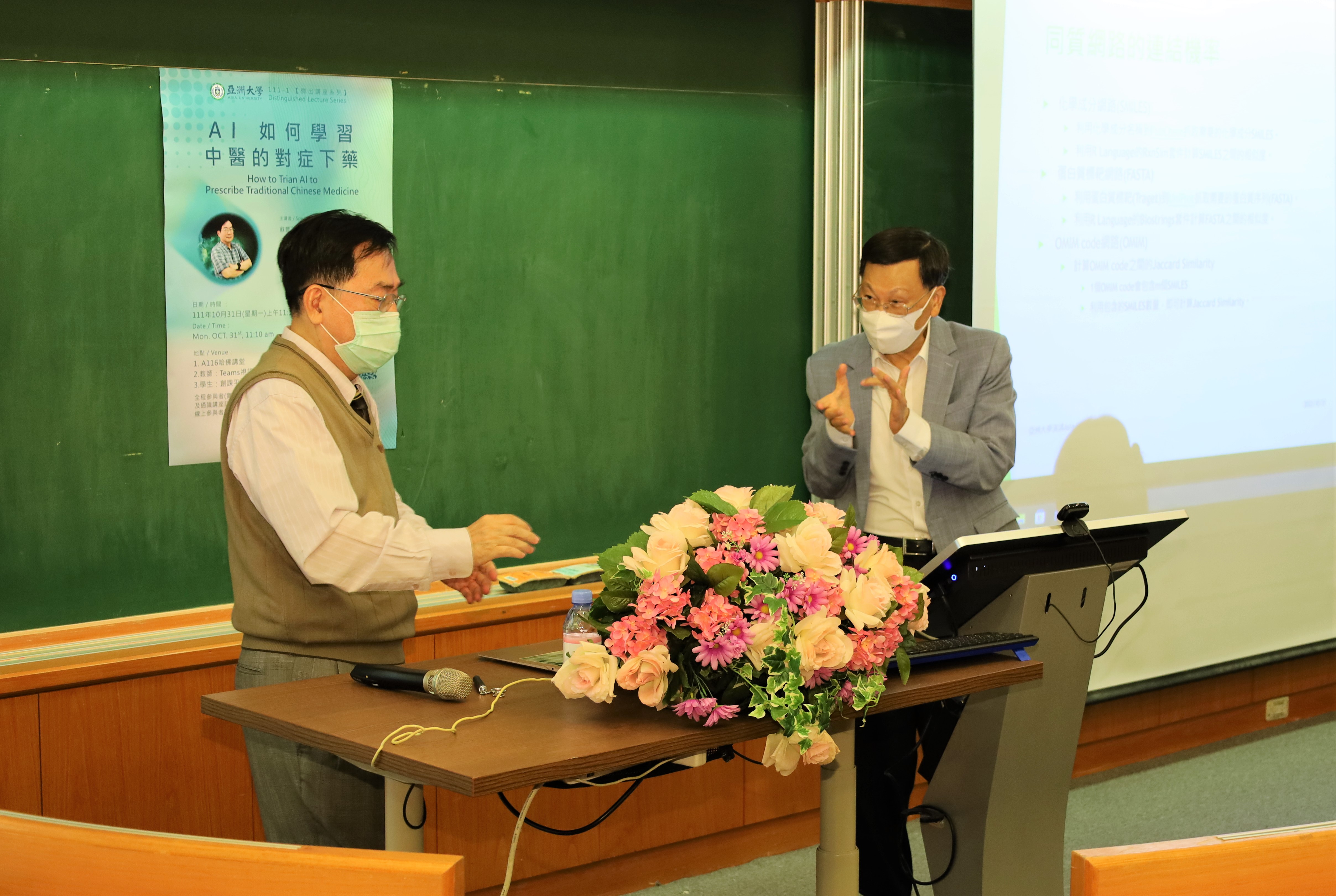 圖為亞大校長蔡進發(右)，與清大教授蘇豐文討論AI在中醫上的運用。