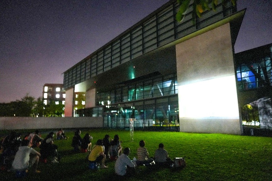 圖為亞美館外的露天電影院，吸引大批亞大師生和附近住戶，席地而坐在草地上觀賞電影。