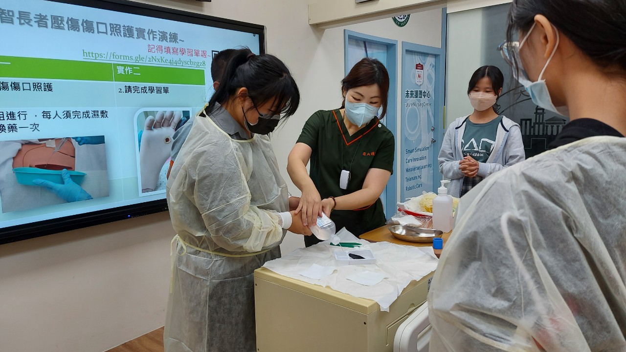 圖為亞大護理系老師彭逸稘，帶領同學在未來護理中心智慧病房，實際操作高齡者傷口清瘡。