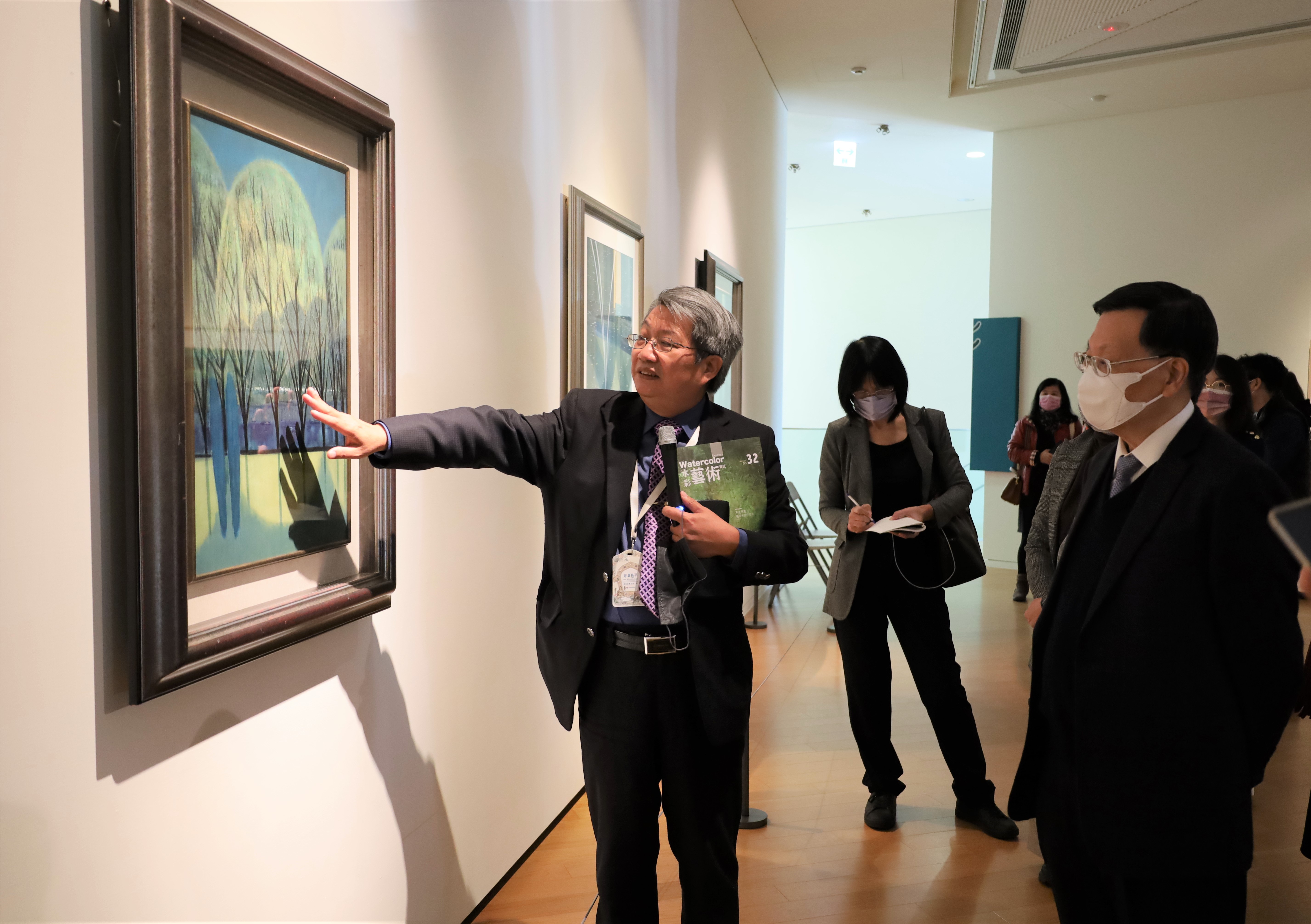 圖為亞大校長蔡進發(右)在展場，聽亞美館館長潘襎導覽介紹蕭如松的作品。
