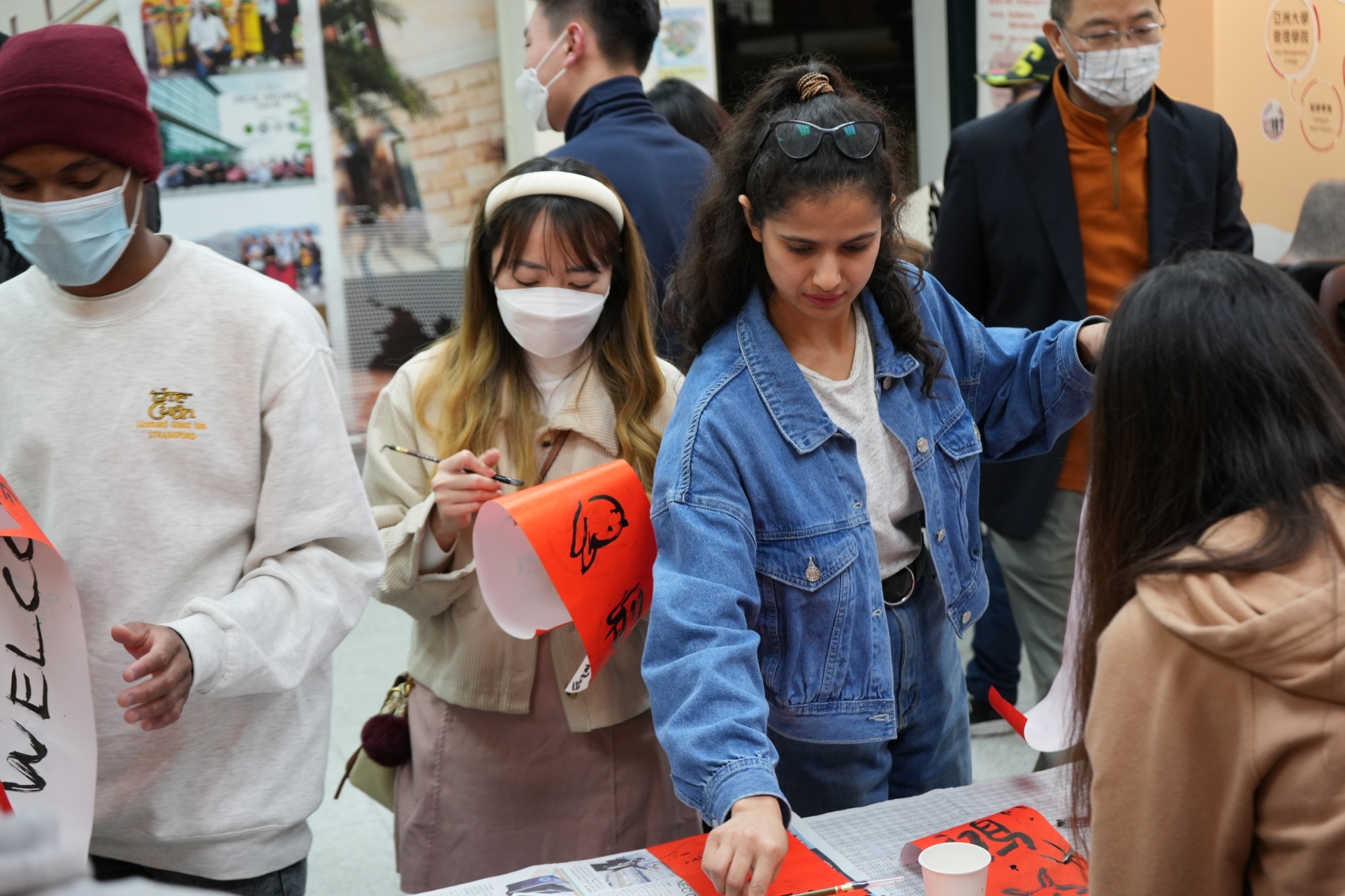 图为在「英文好时光」活动中,亚大管院双联学制同学与国际生一起体验写春联、介绍春联字句的含意。