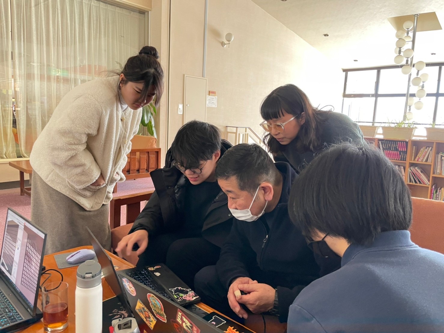 图为八幡平朝阳饭店总经理工藤正人(左3)，与4位研习同学一同讨论饭店的改造设计。