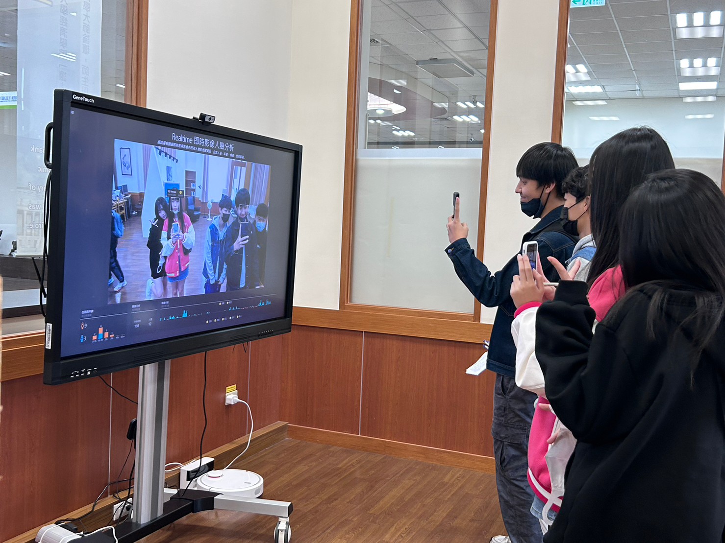 圖為參加體驗營的高中生，在亞大圖書館體驗有趣AI互動。