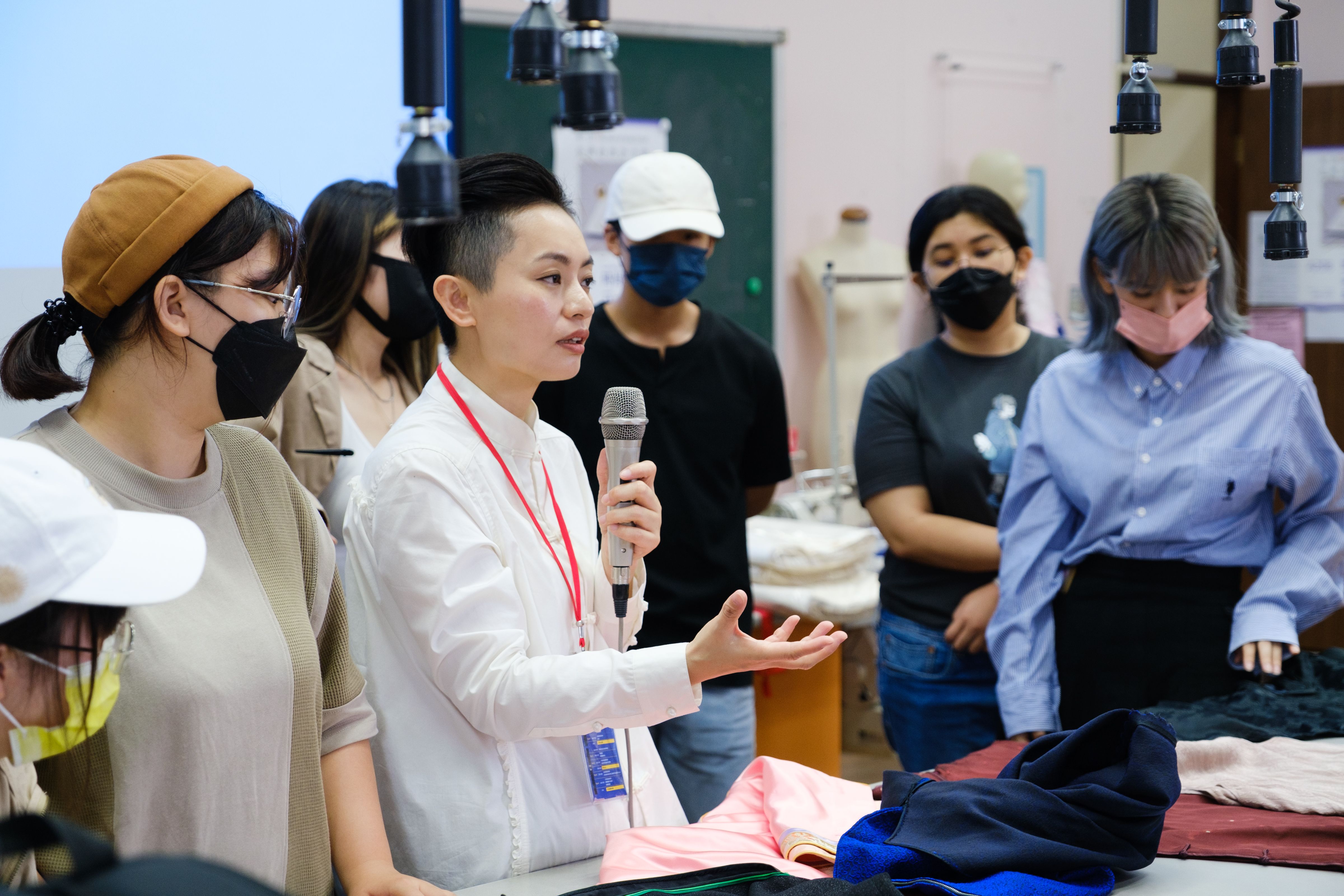 香港設計大師林春菊(左2)，與學員討論服裝作品剪裁方式。