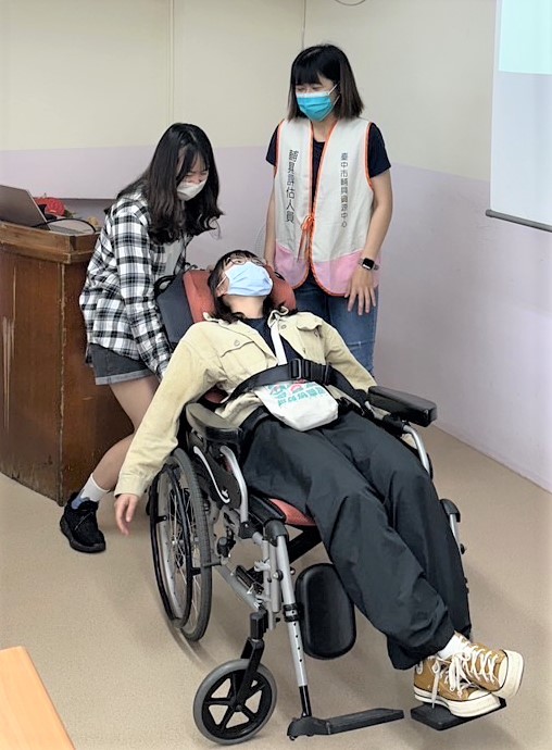 圖為亞大職治系同學體驗空中傾倒輪椅，利用往後翹時椅面的前後高低、重心轉移，避免高齡者身體傾斜時被壓傷。