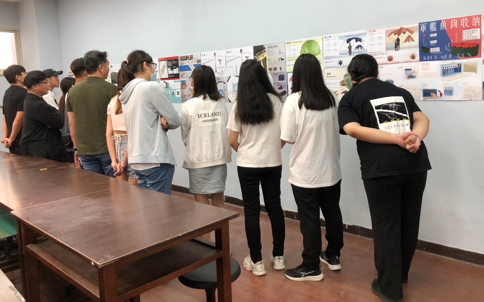 圖為亞大發明中心舉辦「國際設計菁英團成果展」，同學參觀海報作品。
