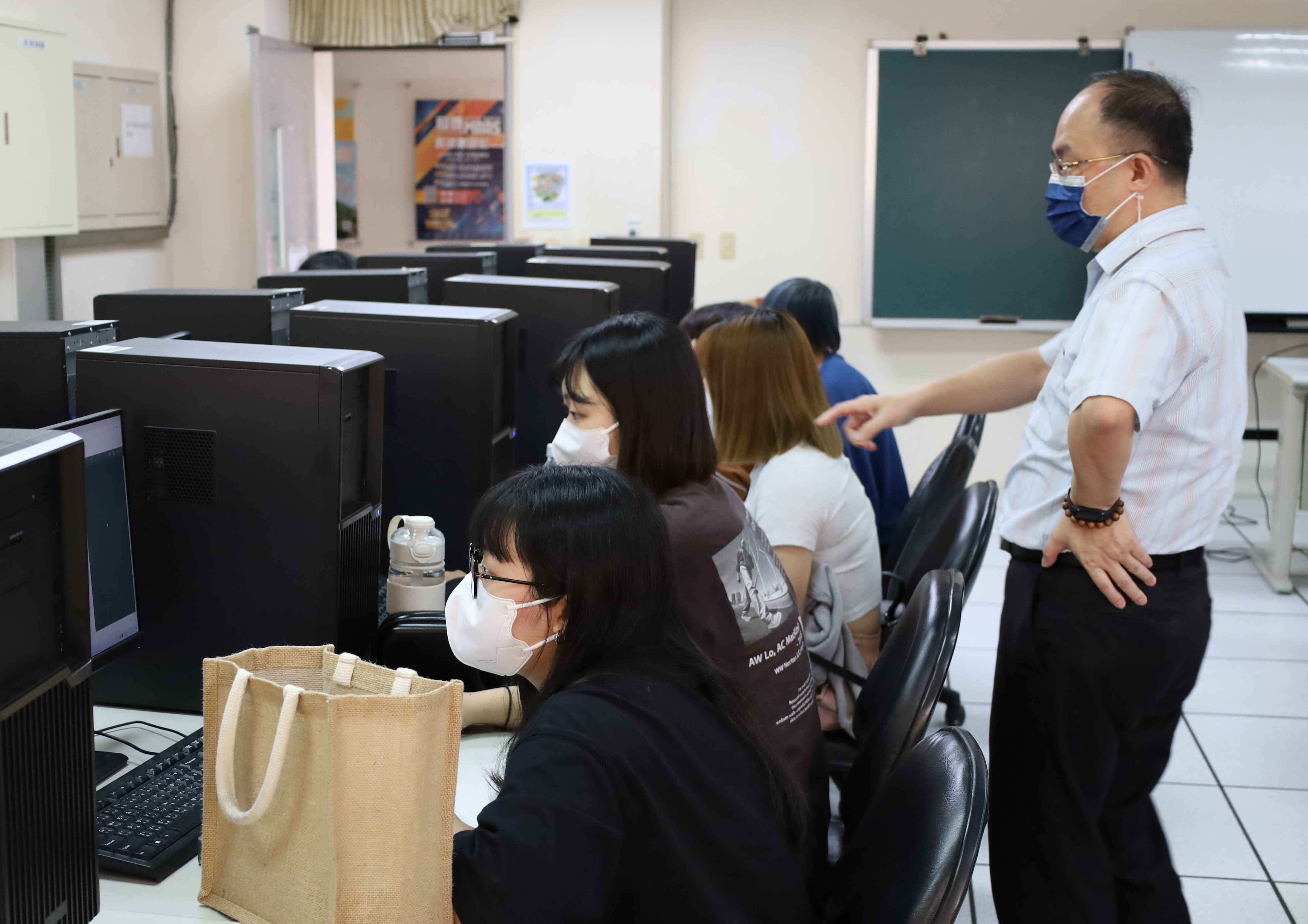 圖為亞大資傳系主任陳士農(右)，在課堂上教導同學如何運用軟體，去生成虛擬整合的照片。