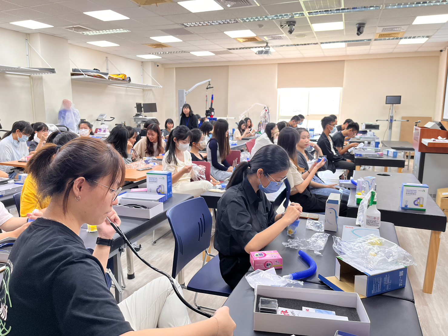 圖為亞大醫健學院舉辦「新生微學程」，同學體驗操作呼吸訓練器材、聽診器、肺計量器等專業儀器。