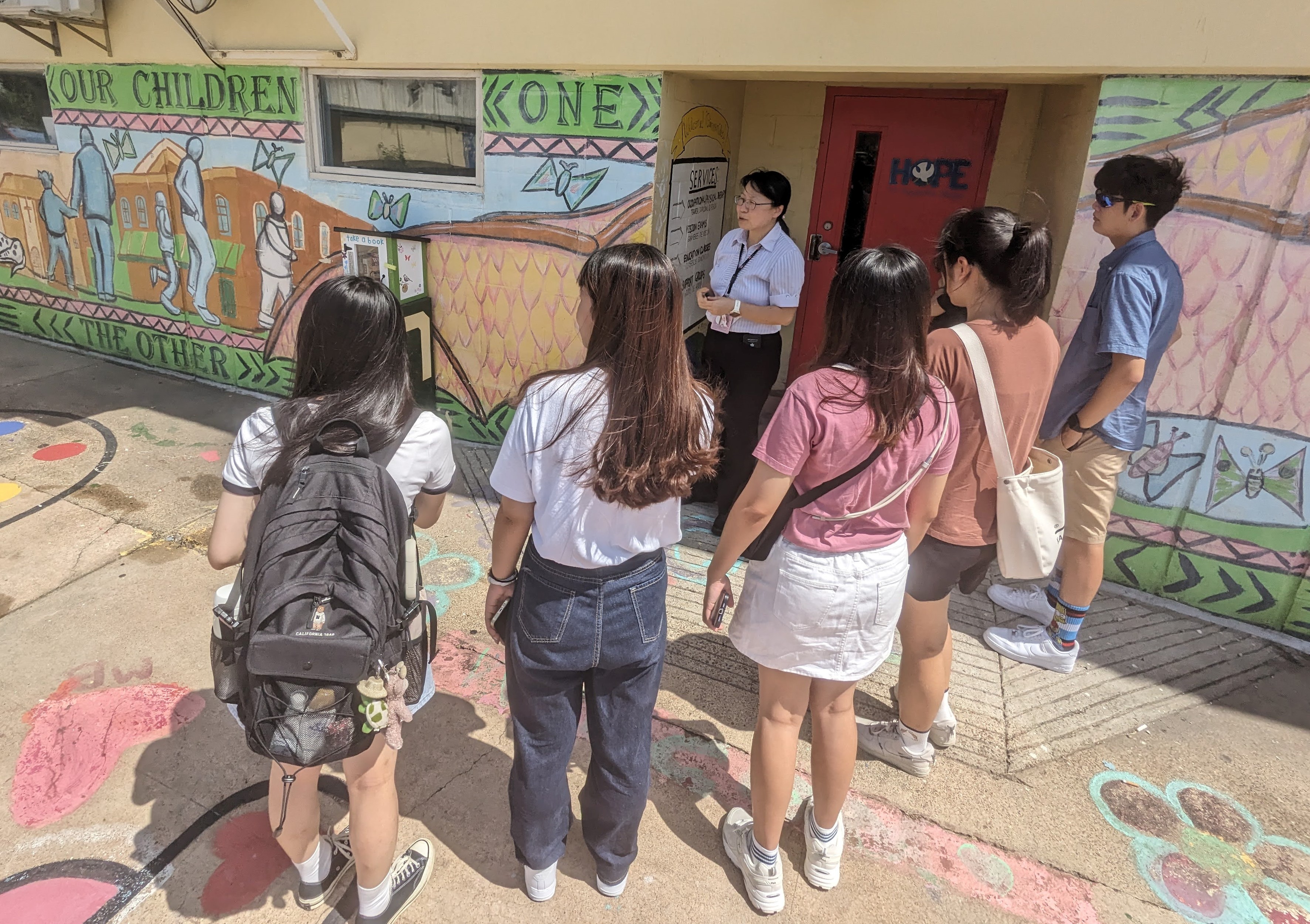 The image shows students from the Department of Healthcare Administration visiting a student clinic in the United States that helps low-income families.