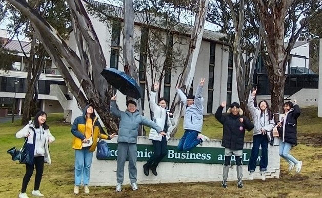 圖為亞大商設系同學，在澳洲新英格蘭大學商學院門口開心合影。