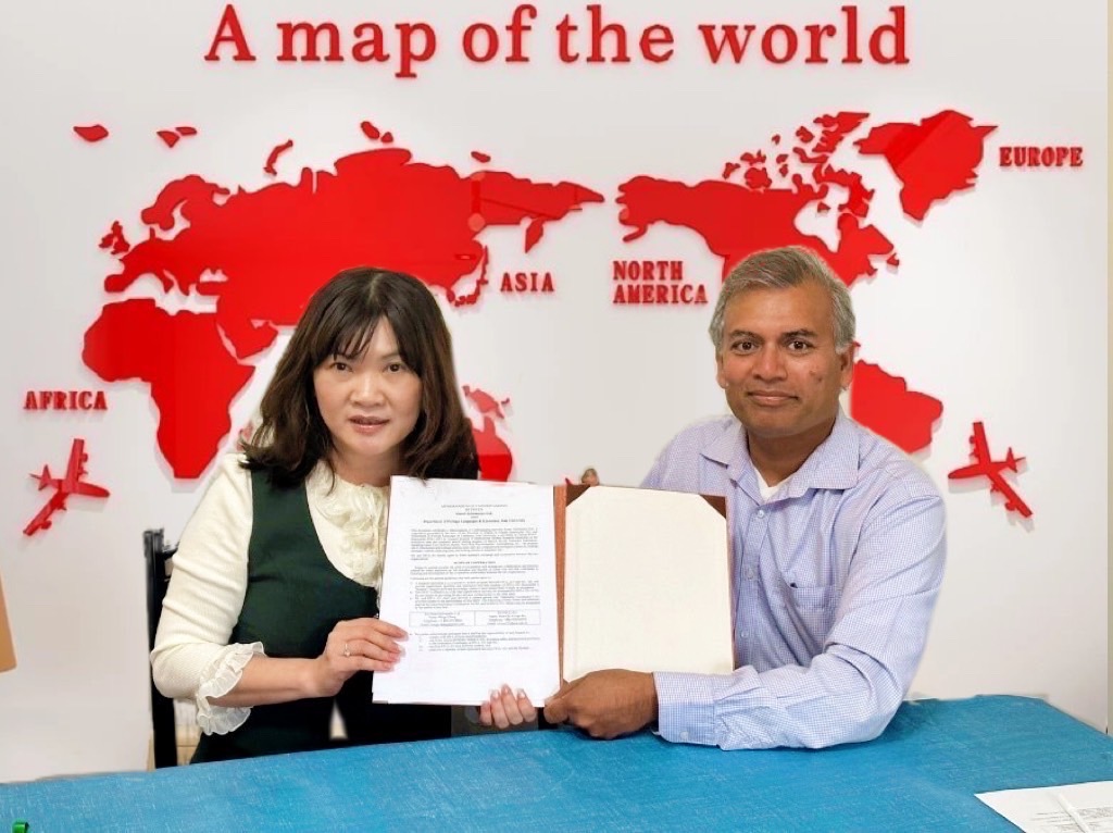 圖為亞大外文系吳文琪老師(左)，與加拿大Smart Informatics Ltd.總經理Vive Kumar 簽署海外實習合約。