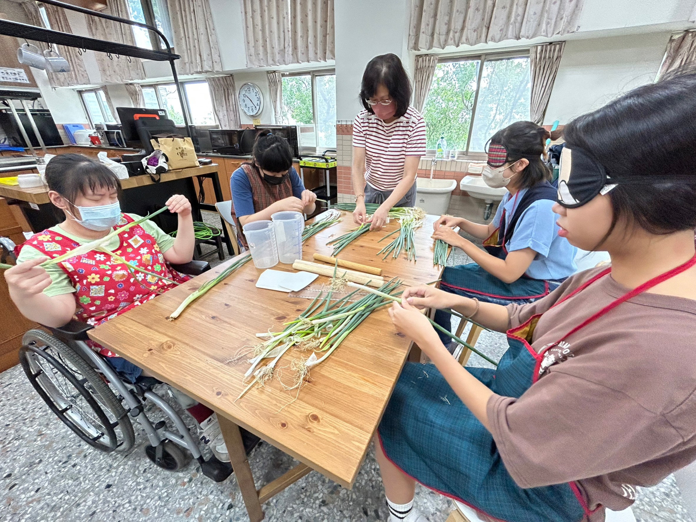 圖為亞大商品系同學，在惠明盲校體驗戴眼罩做蔥餅。