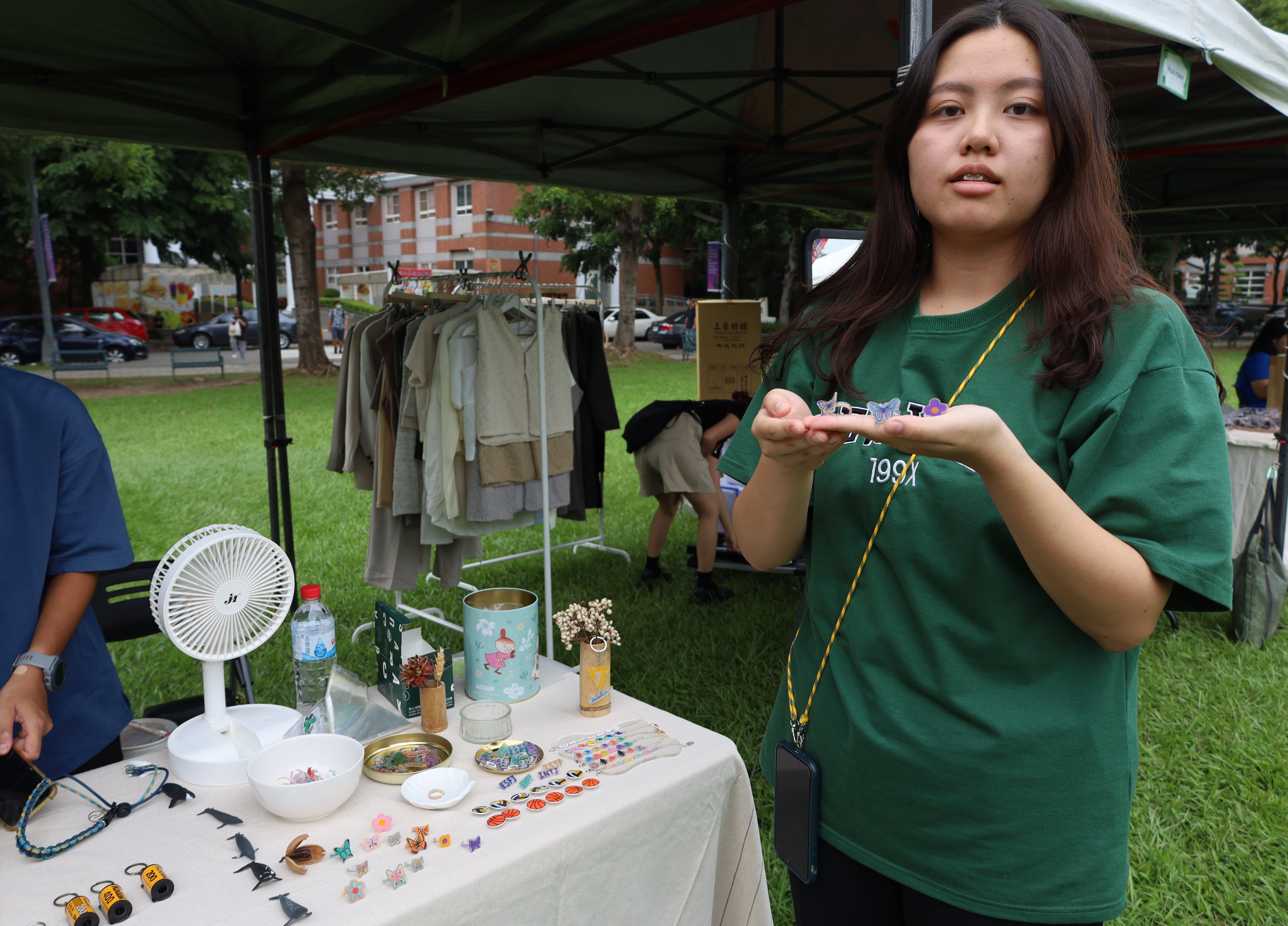 圖為亞大社工系楊芯锫同學，首次擺攤販售自製的手繪戒子。