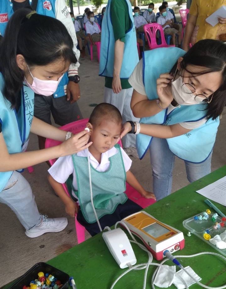 圖為亞大聽語系林琪溱（左）、曾坤郁（右1）同學，為泰國兒童進行耳聲傳射檢查。