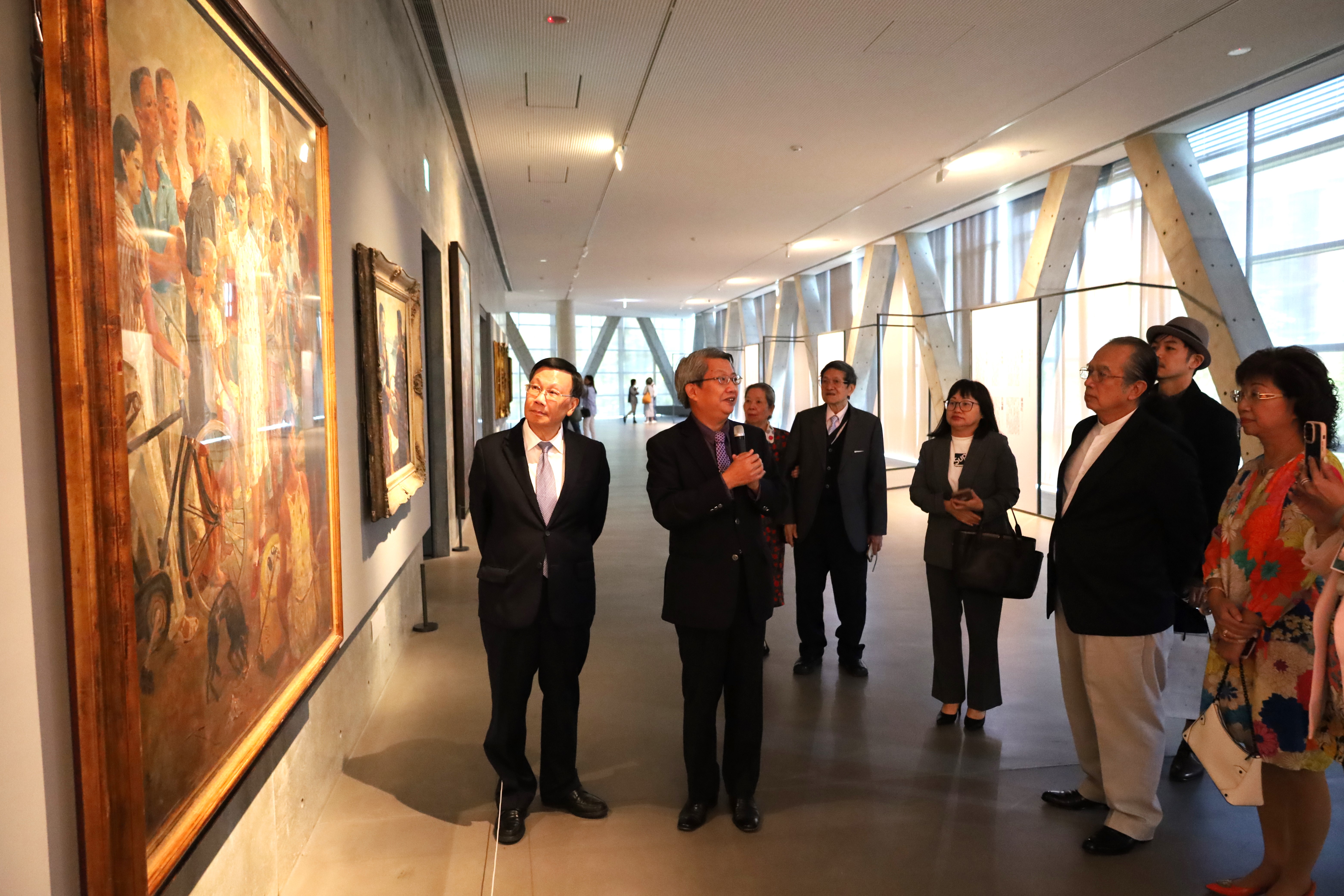 圖為亞大校長蔡進發(左1)、亞大現代美術館長潘襎(左2)等，欣賞台灣知名畫家李石樵的代表性作品《市場口》。