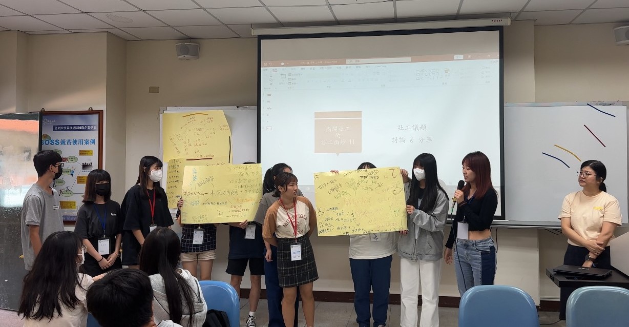 图为学员上台发表分享小组讨论成果，由陈秀静老师(右1)评论。