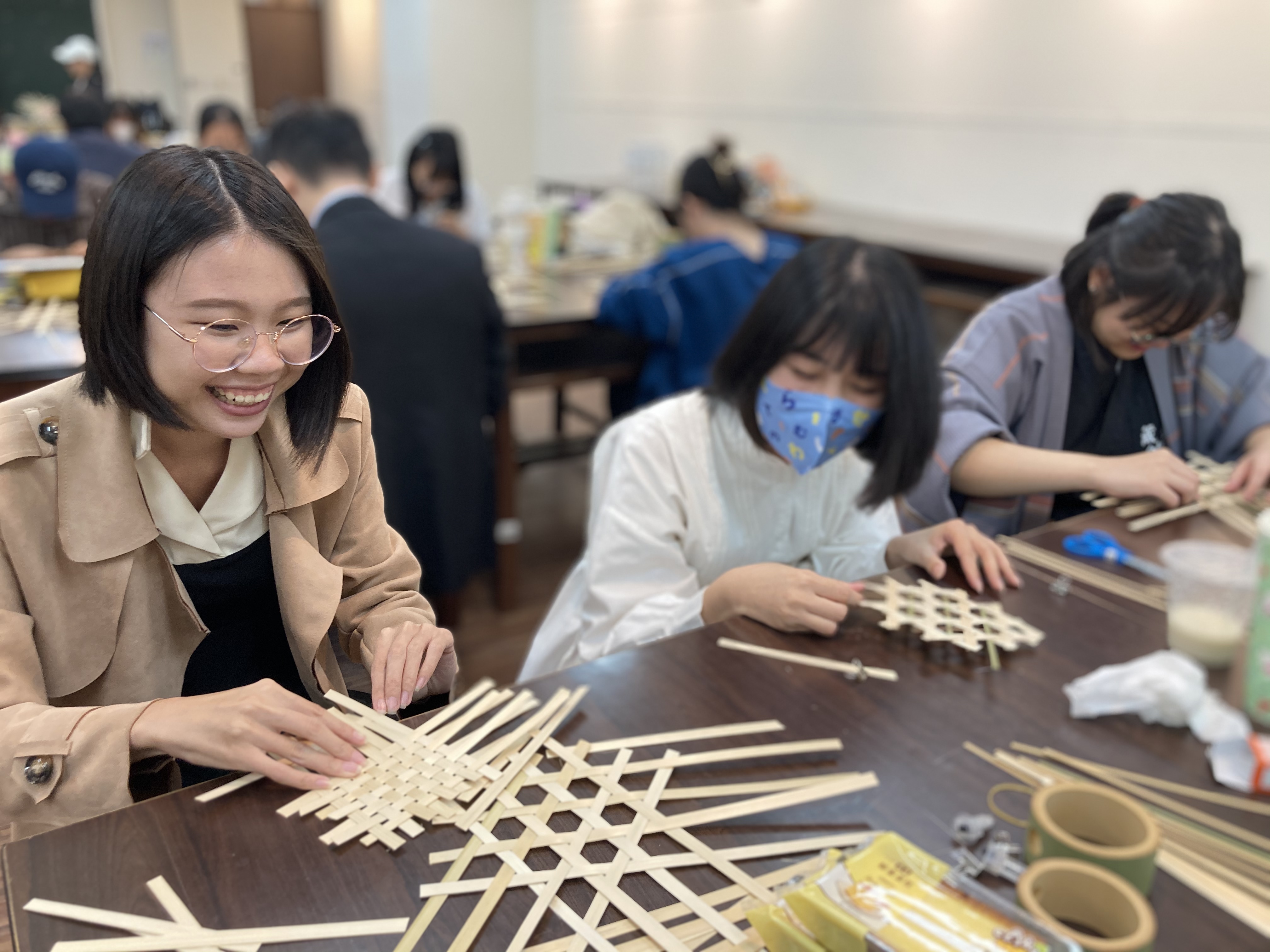 图为参与学员踊跃，兴致盎然学习竹编。