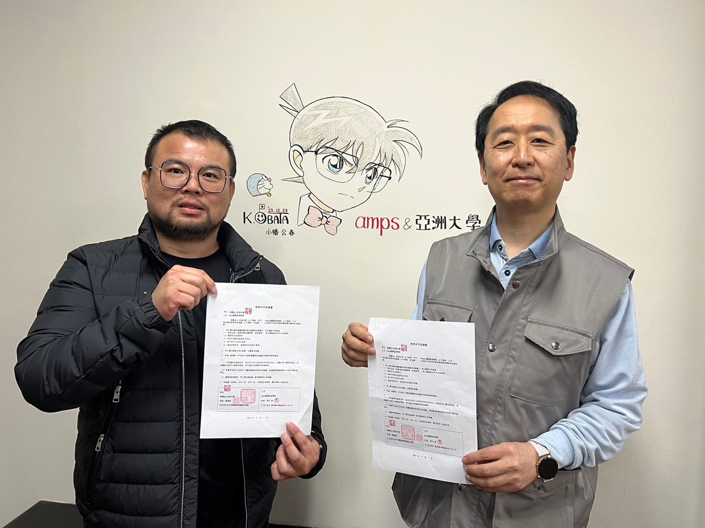 图为亚大数媒系主任赵文鸿(左)代表亚大，与小幡公春老师代表日本Amps国际动漫学院，签订为期5年的教育合作协议书。