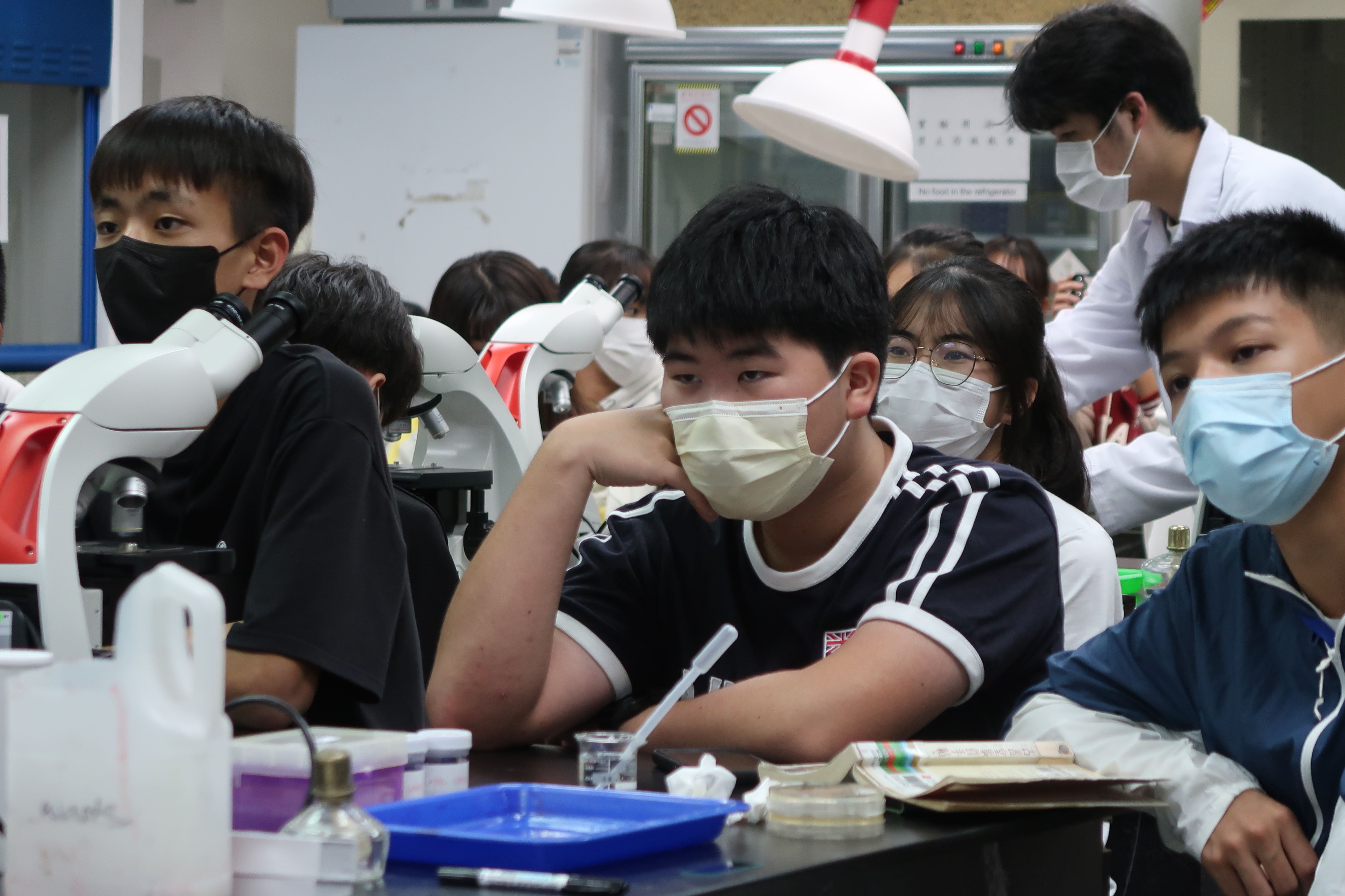 圖為參加一日體驗營的高中生，仔細聆聽醫檢實驗內容、操作步驟。