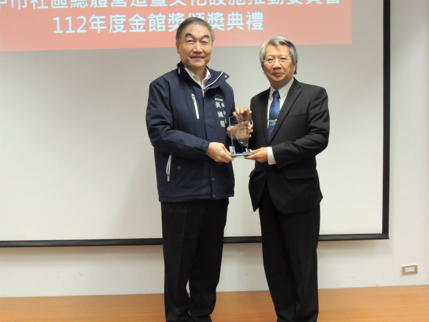 圖為台中市副市長黃國榮(左)頒發「金館獎」，由亞美館長潘襎代表領獎。