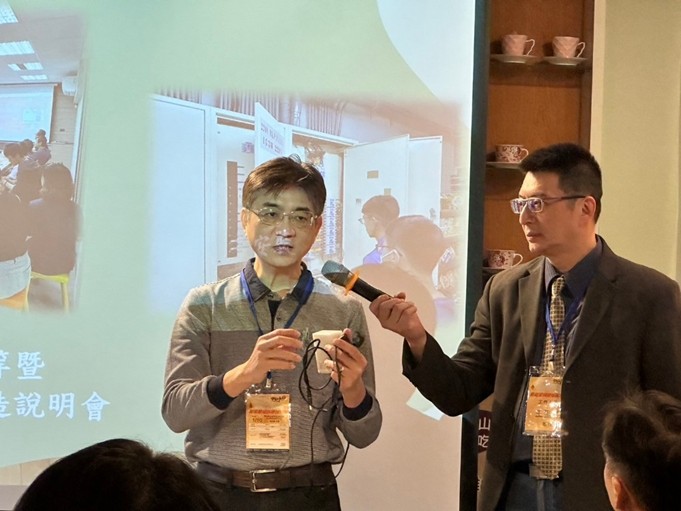 圖為亞大商應系陳大正教授(左)，為店家展示用電感測器的運作方式。