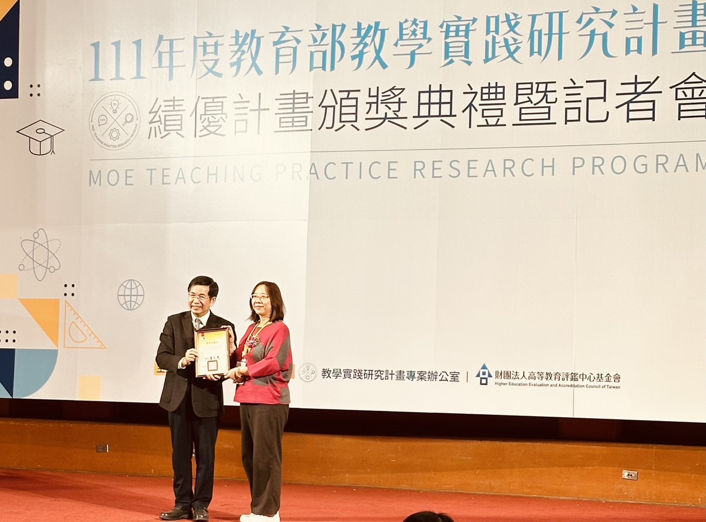 圖為教育部長潘文忠（左），頒獎給亞大休憩系童秋霞老師。