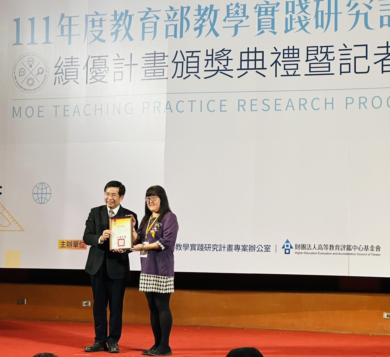 圖為教育部長潘文忠（左），頒獎給亞大護理學系靖永潔老師。