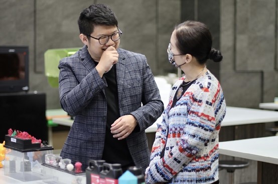图为亚大时尚系主任林青玫(右)，与张超闵设计师讨论交流。