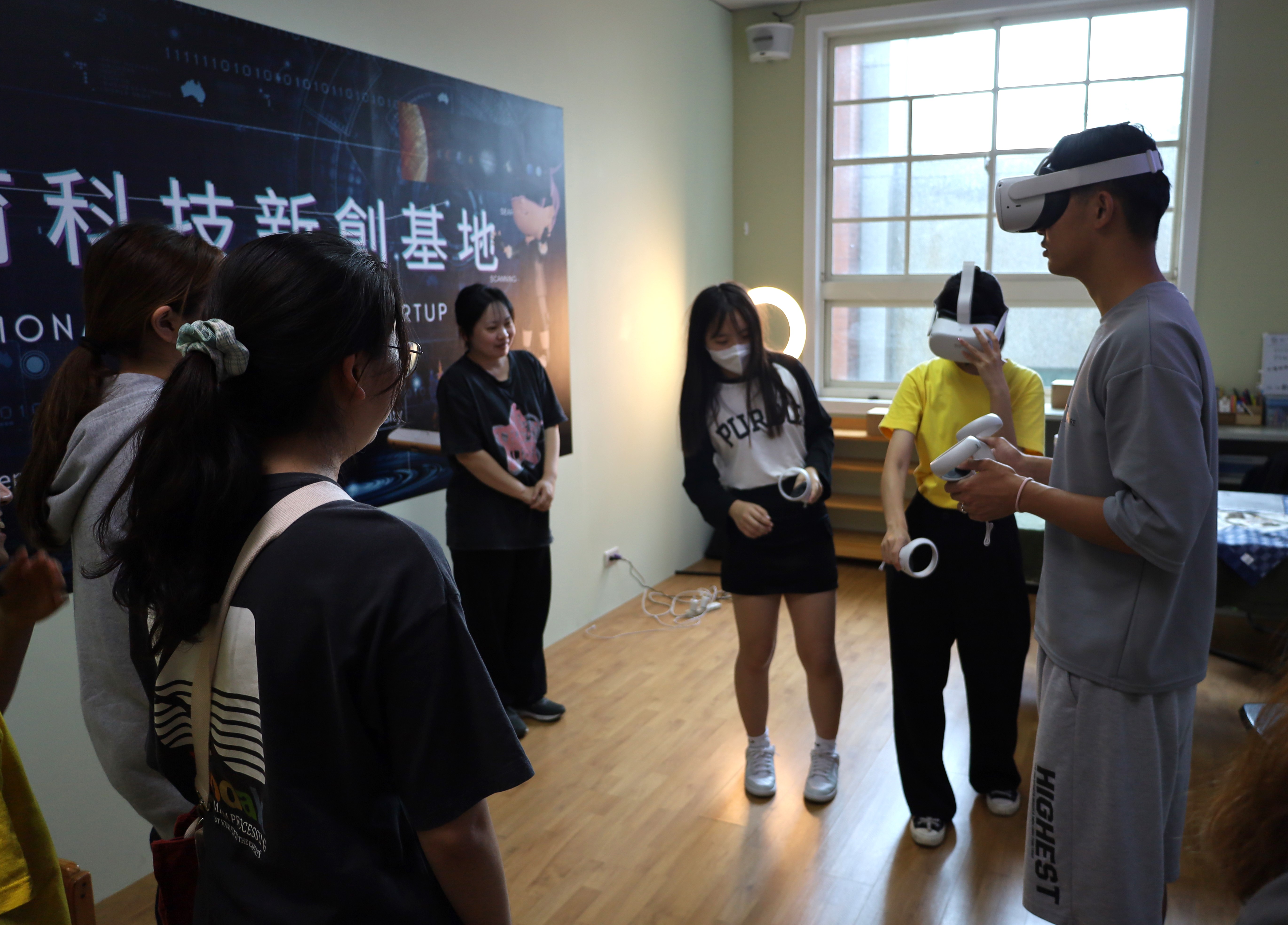 圖為考生在亞大幼教系「科技新創基地」，戴上VR眼鏡體驗。