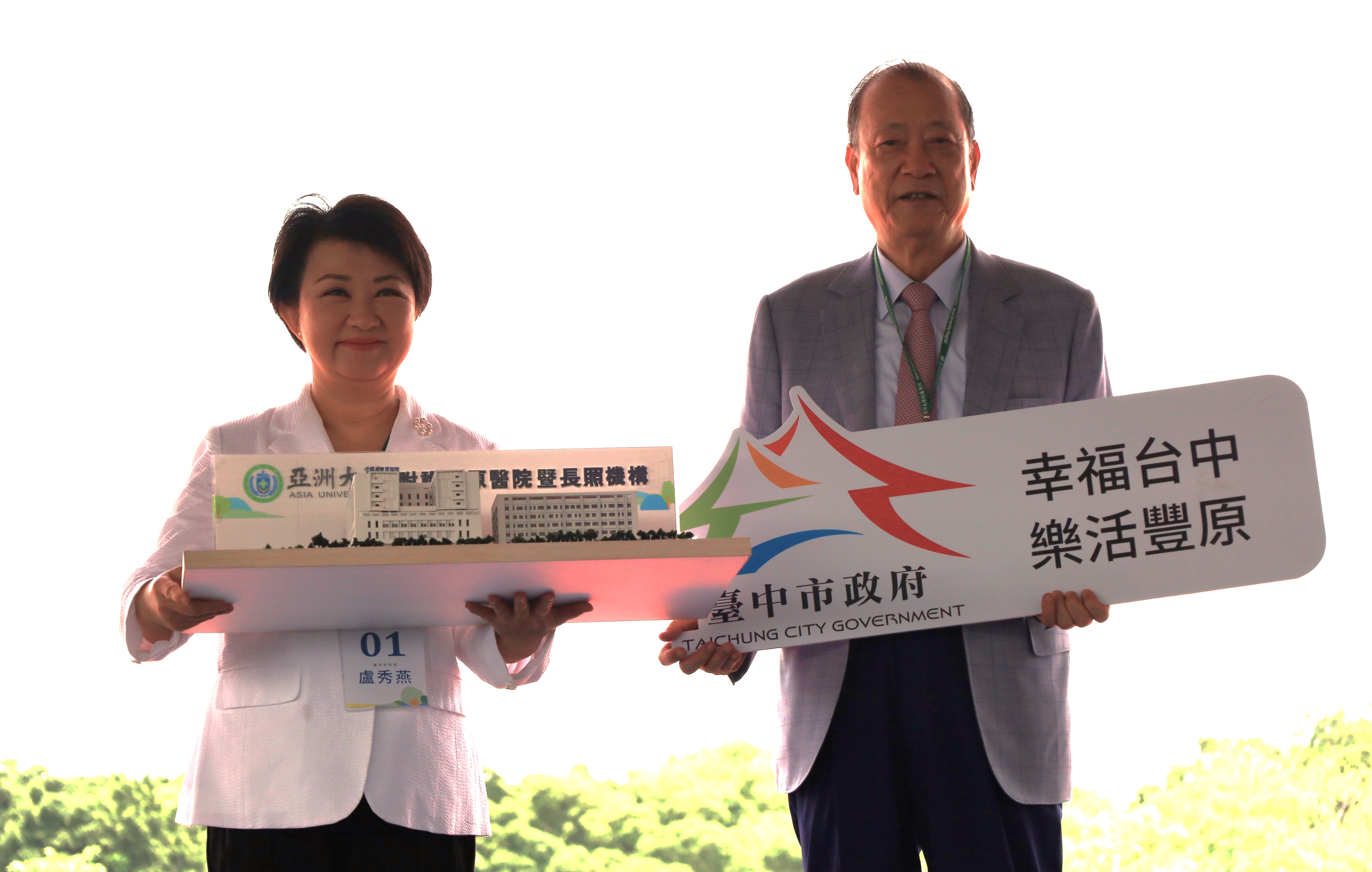 圖為台中市長盧秀燕(左)、亞大創辦人蔡長海(右)交換信物，象徵「亞洲大學豐富健康產業園區」的興建，是「幸福台中、樂活豐原」象徵。