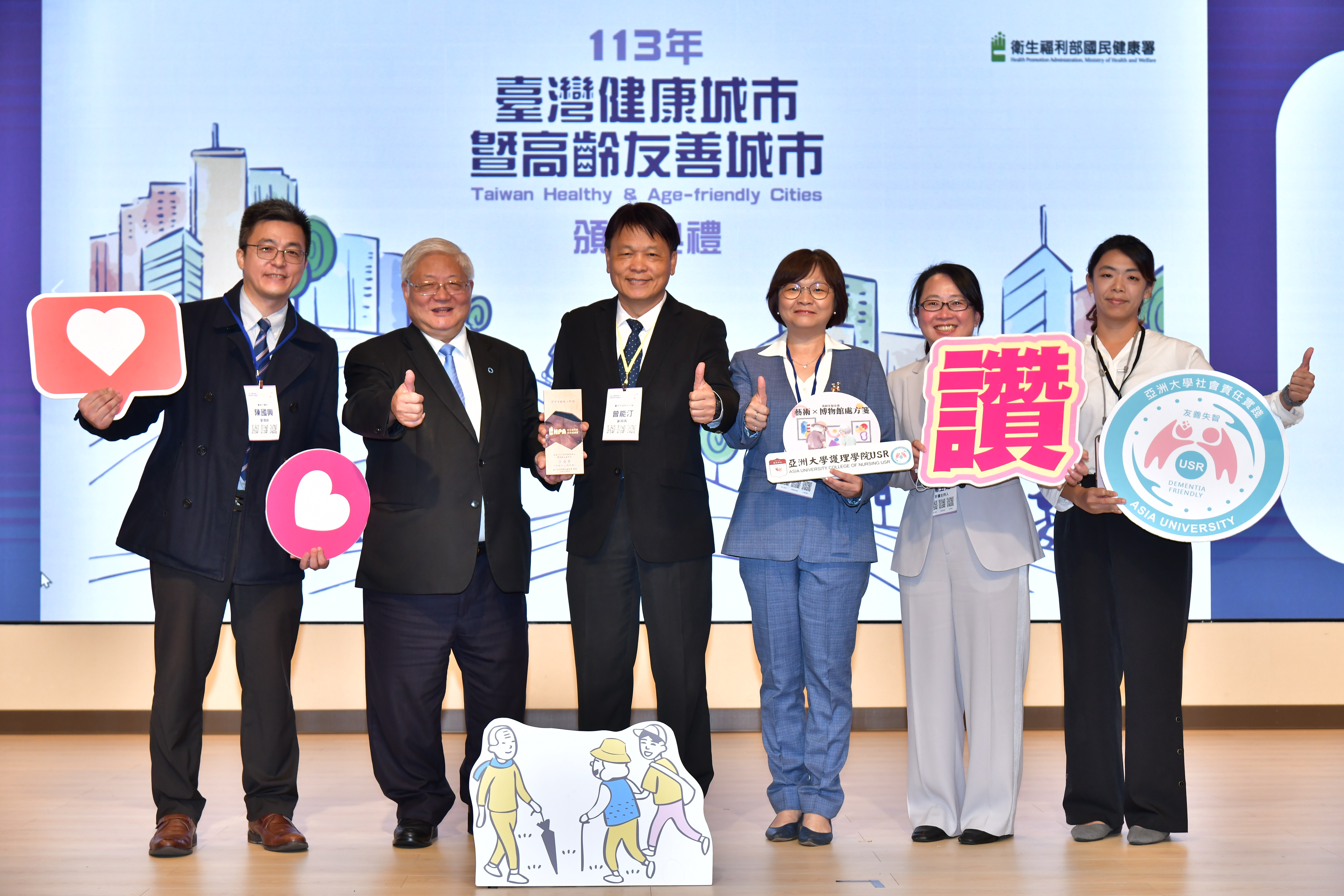 图为台中市文化局副局长曾能汀(左3)、亚大护理学院长吴桦姗(左4)，代表接受「共老奖」颁奖。