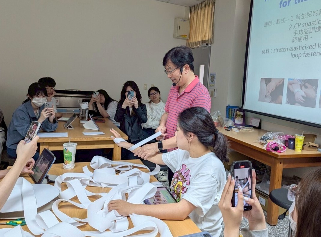 張瑞昆老師(站立者)教導同學利用彈性繃帶、黏扣帶,製作矯正肢體位置的束帶。