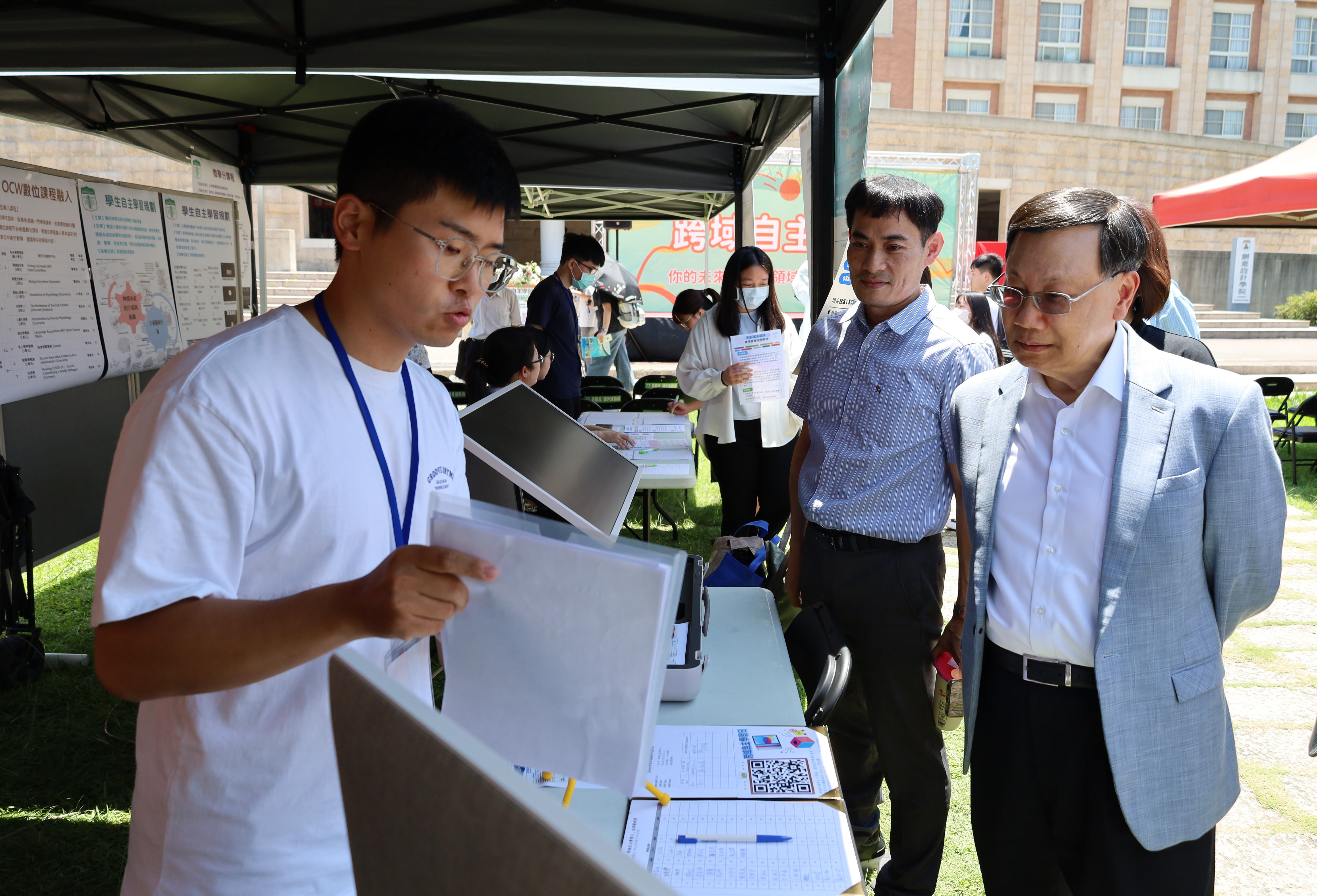 亞大校長蔡進發(右)，參觀資電學院攤位，了解「教育大數據微學程」。