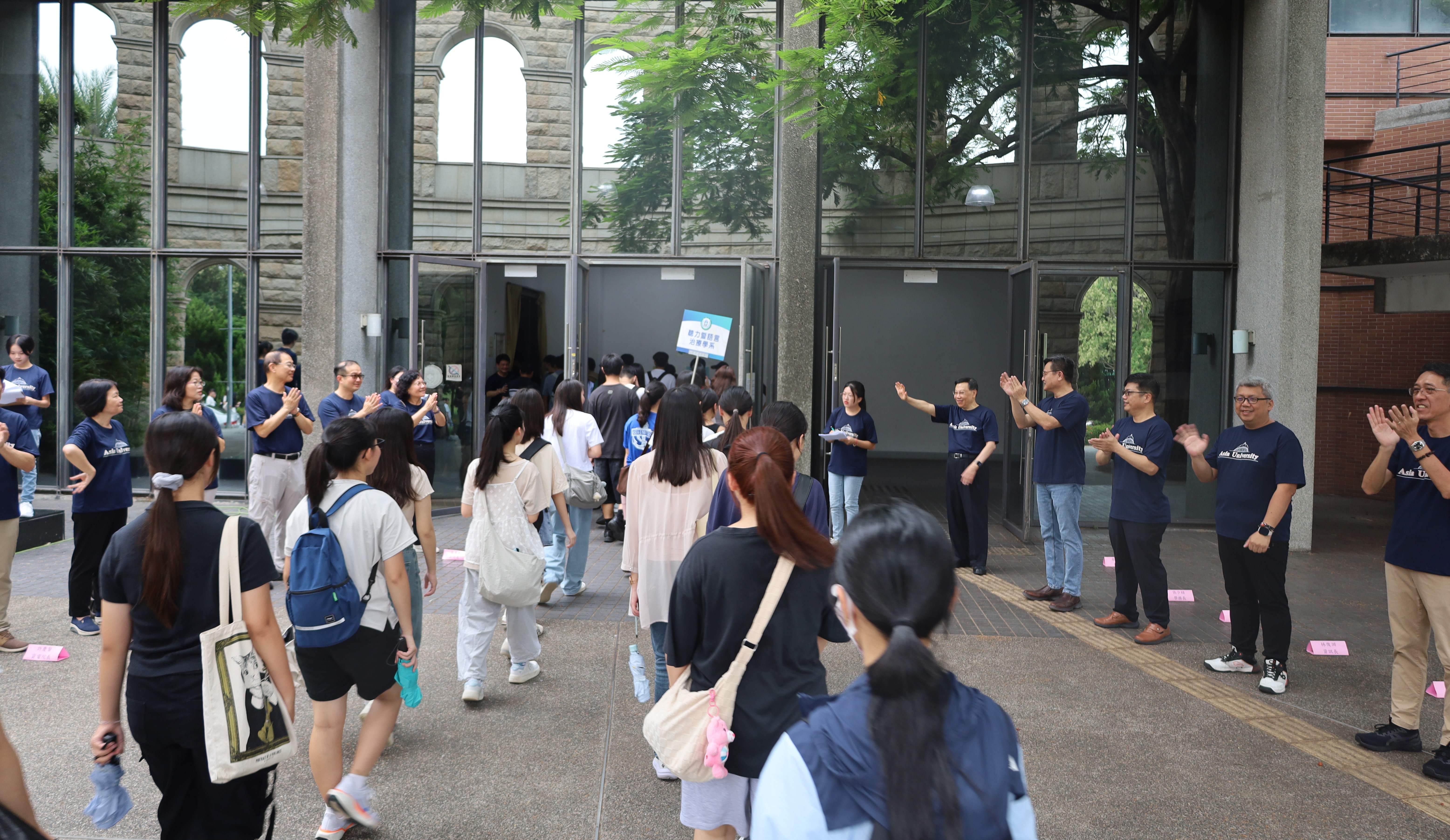 亞大新生始業式在體育館舉行，師長揮手歡迎新生加入亞大大家庭。