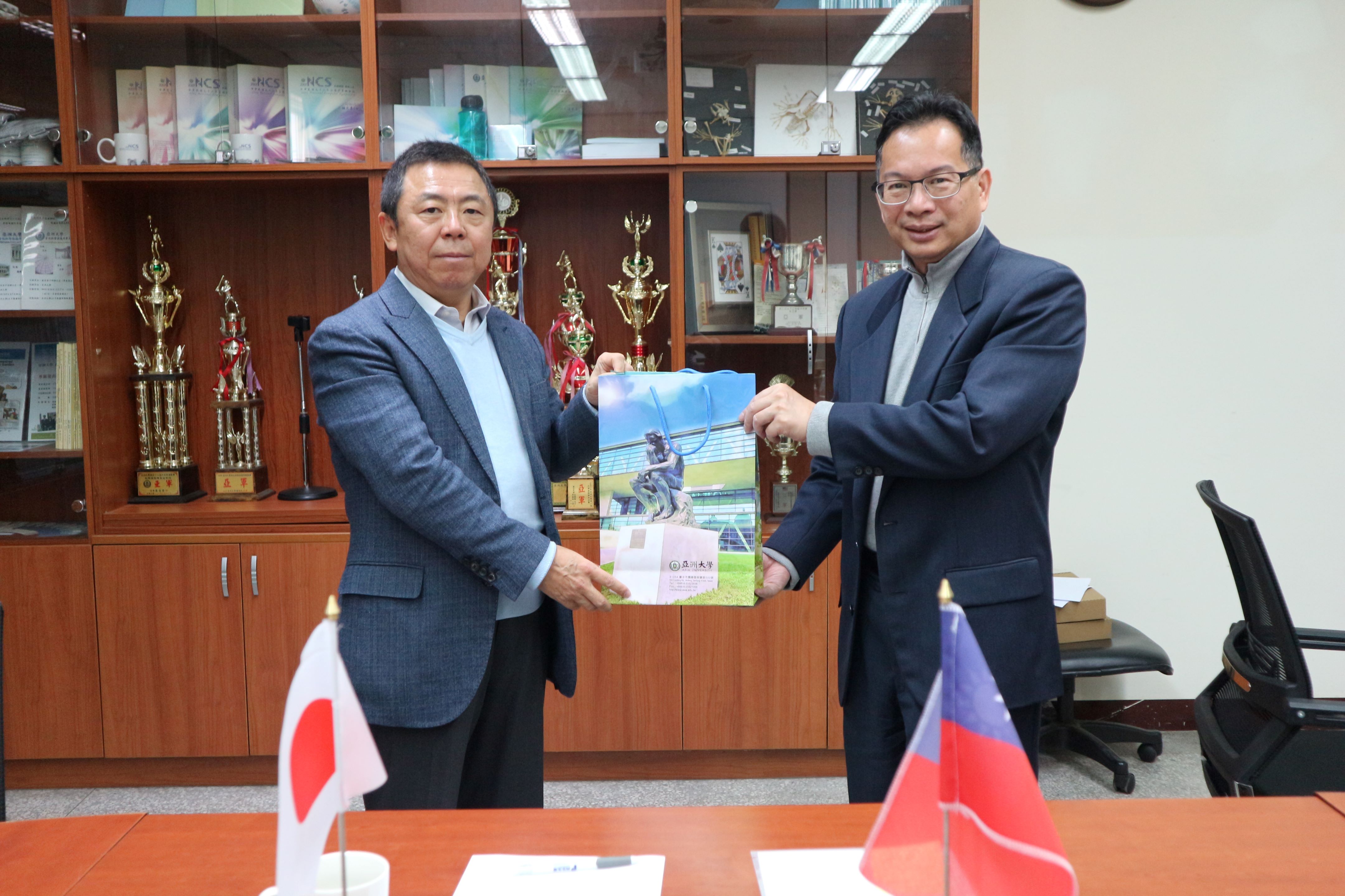 圖為亞大國際長歐仁和(右)、日本福岡大學國際長李明哲(左)代表簽署合作備忘錄,將強化資工、生醫領域的交流。