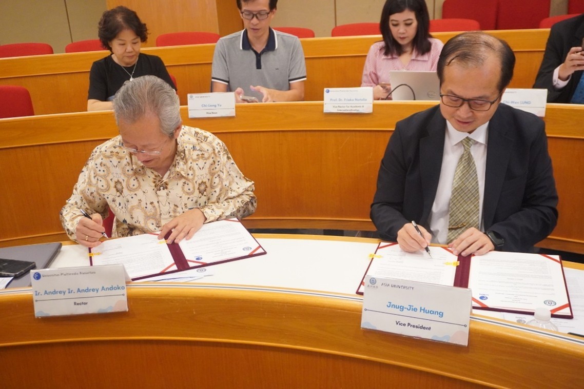 亞大副校長黃俊杰(右)、印尼多媒體大學校長Ir. Andrey Andoko(左)代表，簽署合作備忘錄。