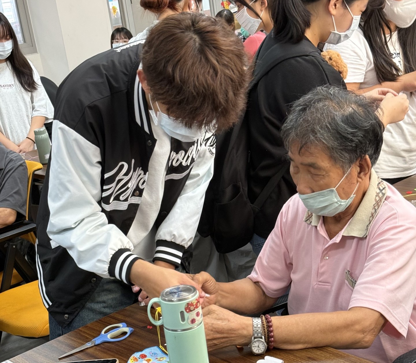 亞大長照系同學,陪伴長輩製作手工吊飾。